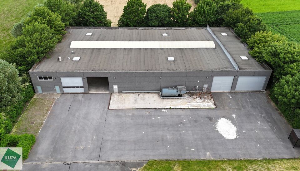 Ruime bedrijfssite met nieuwbouw kantoorgebouw, achterliggende loods van circa 1.680 m&sup2; en aansluitend weiland.
Vooraan aan de straat bevindt zich een recent en luxueus kantoorgebouw met ca. 160 m&sup2; bebouwde oppervlakte, bestaande uit gelijkvloers, eerst