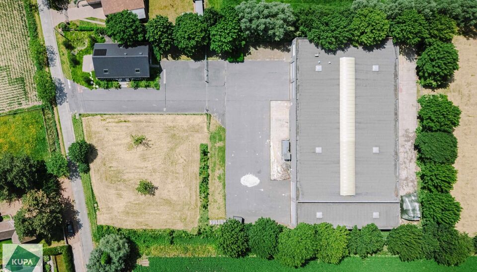 Ruime bedrijfssite met nieuwbouw kantoorgebouw, achterliggende loods van circa 1.680 m&sup2; en aansluitend weiland.
Vooraan aan de straat bevindt zich een recent en luxueus kantoorgebouw met ca. 160 m&sup2; bebouwde oppervlakte, bestaande uit gelijkvloers, eerst