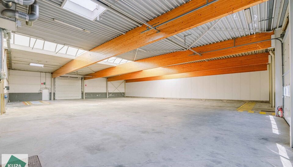 Ruime bedrijfssite met nieuwbouw kantoorgebouw, achterliggende loods van circa 1.680 m&sup2; en aansluitend weiland.
Vooraan aan de straat bevindt zich een recent en luxueus kantoorgebouw met ca. 160 m&sup2; bebouwde oppervlakte, bestaande uit gelijkvloers, eerst